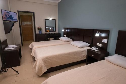 a hotel room with two beds and a mirror at Democritus in Komotini