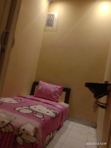 - une petite chambre avec un lit en kitty hello et des draps roses dans l'établissement FM PENGINAPAN, à Blitar