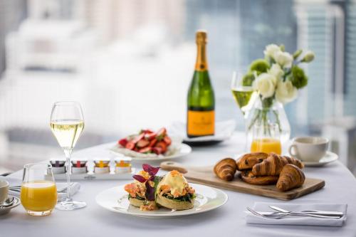 a table with plates of food and a bottle of wine at Sofitel Sydney Darling Harbour in Sydney