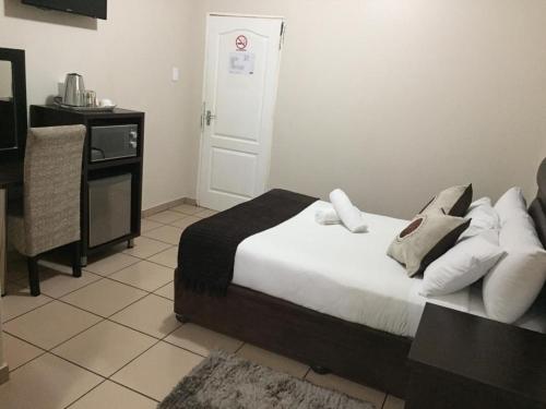 una camera con letto, tavolo e porta di Bayside Hotel Empangeni a Empangeni