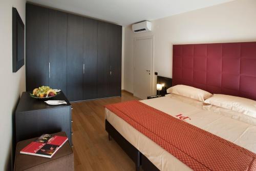 Schlafzimmer mit einem großen Bett mit einem roten Kopfteil in der Unterkunft Residence Calissano in Alba