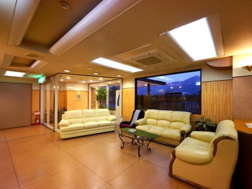 a lobby with couches and a table in a building at Aridagawa Onsen Hotel Sunshine in Arida