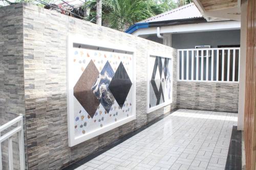 a wall with paintings on it next to a house at Monallan Boracay Hotel in Boracay