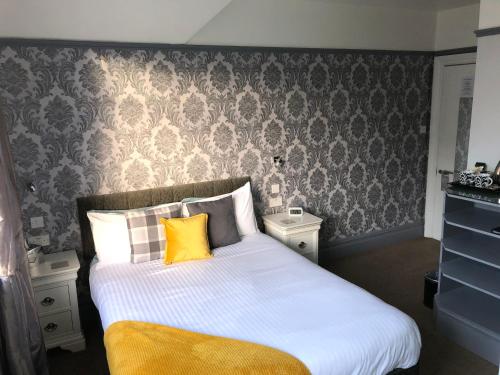 a bedroom with a large bed with yellow pillows at Swanage Haven Boutique Guest House in Swanage