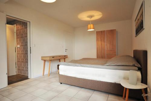 a bedroom with a large bed and a table at Lagadin Lakeview Apartment in Ohrid