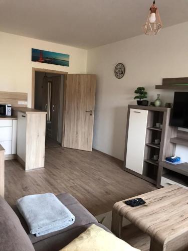 a living room with a table and a kitchen at Apartmán Monny in Frymburk