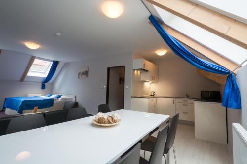 a kitchen and living room with a white table and chairs at Adeba Hotel in Prague