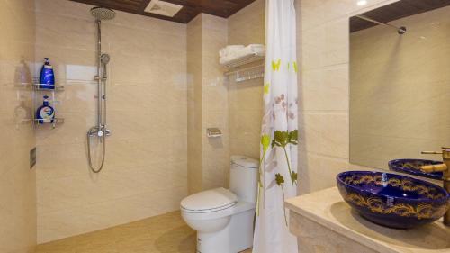 a bathroom with a shower and a toilet and a sink at Floral Hotel · Spring Guesthouse Zhangjiajie in Zhangjiajie
