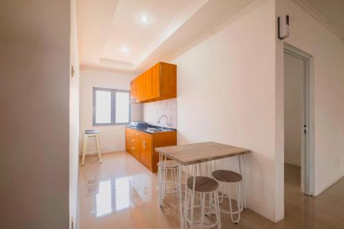 a small kitchen with a wooden table and stools at RedDoorz near Exit Toll Moh. Toha in Bandung