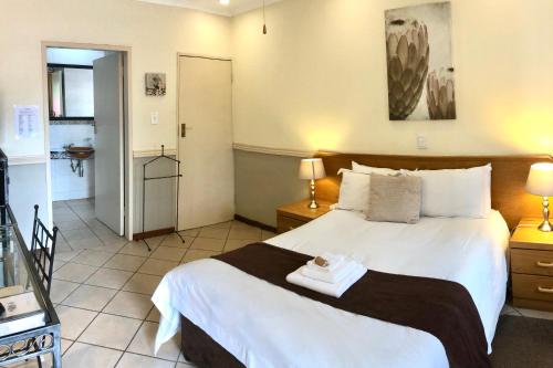 a bedroom with a large white bed in a room at Clubview Guest House in Centurion