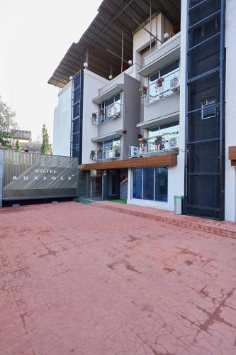 a large apartment building with a red brick courtyard at Aureole Mrida - A Boutique Hotel in Lonavala