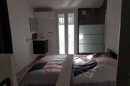 une chambre avec un lit dans une pièce avec une fenêtre dans l'établissement Duplex meublé sortie orange centre, à Orange
