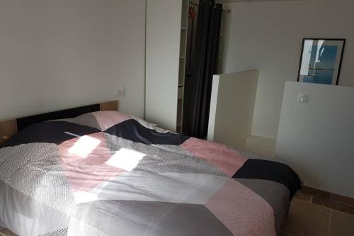 - un lit avec une couette dans l'établissement Duplex meublé sortie orange centre, à Orange