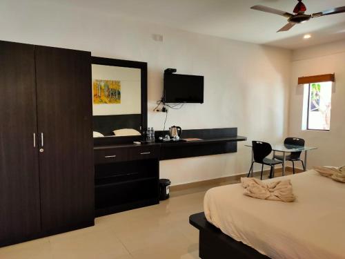 a bedroom with a bed and a dresser with a mirror at Mariaariose - "Melody of the Sea" in Bogmolo