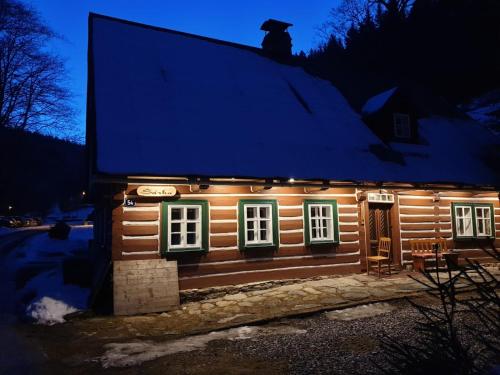 a small log cabin with lights on it at night at Chalupa Šárka in Dolni Dvur