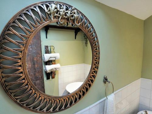 a bathroom with a large circular mirror on the wall at The Coach House in Matlock