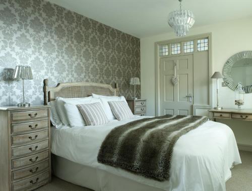 a bedroom with a bed and a dresser and a mirror at East Row Lodge in Whitby