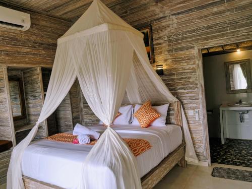 a bedroom with a bed with a canopy at Mesari Hut Lembongan in Nusa Lembongan