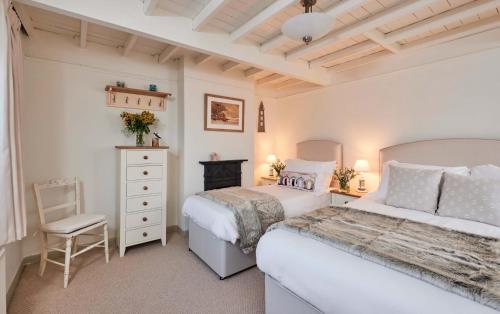 a bedroom with two beds and a dresser at Rigg Cottage in Whitby