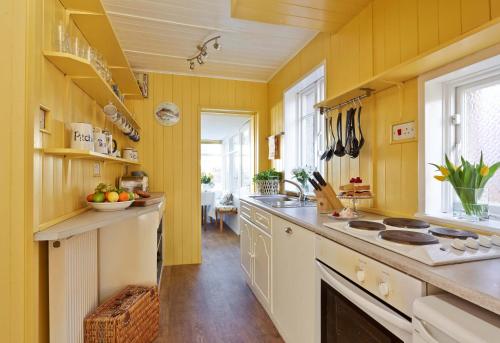 Seacliff Cottage في ويتبي: مطبخ كبير بجدران صفراء وقمة كونتر