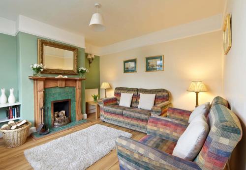 Seacliff Cottage في ويتبي: غرفة معيشة مع أريكة ومدفأة