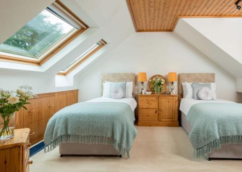 two beds in a attic bedroom with skylights at Seawinds in Whitby