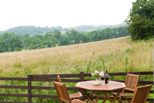 a wooden table with flowers and a bottle of wine at Seawinds in Robin Hood's Bay