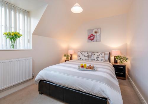 a bedroom with a bed with a tray of fruit on it at Sunny Corner Cottage in Filey