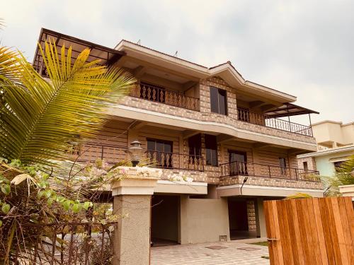 a large building with a balcony and a fence at Neville's Villa - Pet friendly with Pool in Alibaug