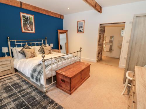 ein Schlafzimmer mit einem Bett und einer blauen Wand in der Unterkunft The Old Workshop in Belford