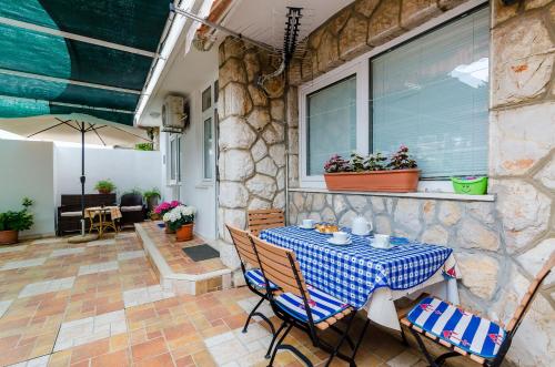 a patio with a table and chairs and a window at Apartments Captain in Dubrovnik