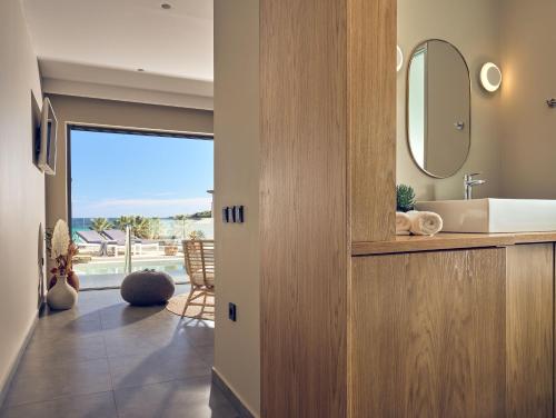 a bathroom with a sink and a mirror at Oceanis Luxury Suites in Kypseli