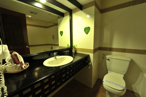 a bathroom with a sink and a toilet and a mirror at City River Hotel in Siem Reap
