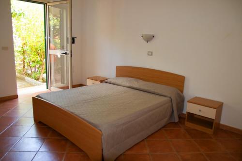 a bedroom with a bed and a sliding glass door at Baia di Zambrone in Zambrone