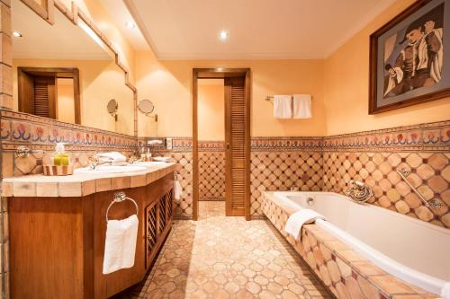a bathroom with a tub and a sink and a tub and a bath tub at Sunderland Hotel in Sundern