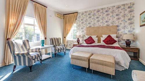 Silver Oaks Boutique Hotel في ديربان: غرفة نوم بسرير ومكتب وكراسي