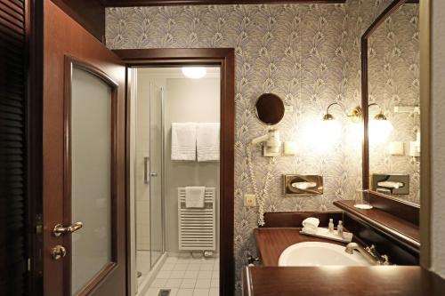 a bathroom with a sink and a mirror at Mercure Hotel Frankfurt Airport Langen in Langen