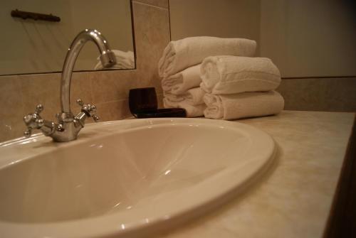 - un lavabo dans la salle de bains avec des serviettes sur un comptoir dans l'établissement La piscine de tonton Jean, à Caunes-Minervois