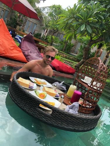 Un uomo in una barca alatabile in acqua di Kompyang Cottage a Nusa Penida