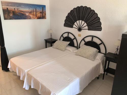 een slaapkamer met twee bedden en een schilderij aan de muur bij Quiet Studio, Incredible views, Climatized pool, FREE WIFI in Arona