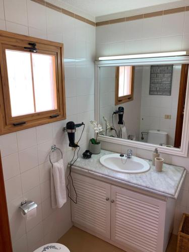 een badkamer met een wastafel en een spiegel bij Quiet Studio, Incredible views, Climatized pool, FREE WIFI in Arona