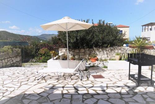 Villa Elan في Mouríon: فناء فيه مظلة بيضاء وبيانو