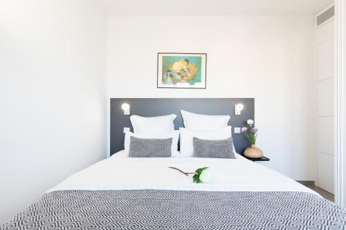 - une chambre dotée d'un lit blanc avec des draps et des oreillers blancs dans l'établissement On la Croisette: luxe 2 bedrooms/ 2 baths, à Cannes
