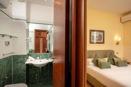 a bathroom with a bed and a sink and a shower at Hotel Colosseum in Rome