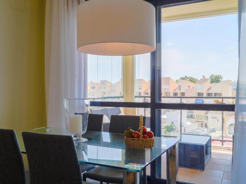 comedor con mesa de cristal y cesta de fruta en Apartment Cosmo Beach-1 by Interhome, en Estepona