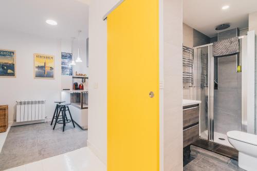 een gele deur in een badkamer met een toilet bij Plaza Nueva apartment by People Rentals in Bilbao