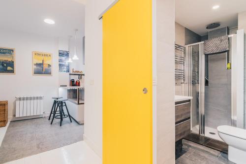 a yellow door in a bathroom with a toilet at Plaza Nueva apartment by People Rentals in Bilbao