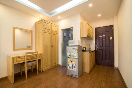 a small kitchen with a table and a refrigerator at RedDoorz Newstyle Apartment Tran Duy Hung in Hanoi
