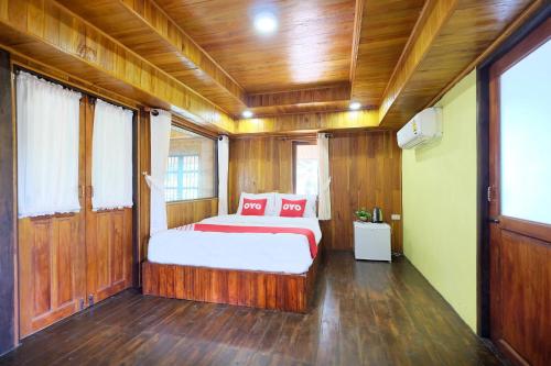 a bedroom with a bed with red pillows on it at OYO 604 Ruen Mai Horm Resort in Trang
