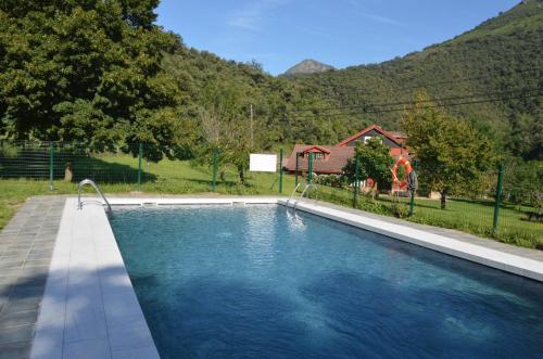 a swimming pool in a yard with a house at Hotel El Jisu in Camaleño